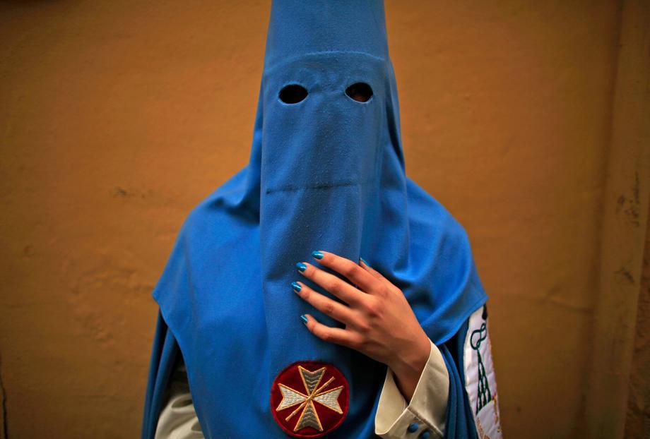 Macarena, a penitent of "San Esteban" brotherhood, poses for a portrait before making her penance during Holy Week in the Andalusian capital of Seville, southern Spain, March 26, 2013. 