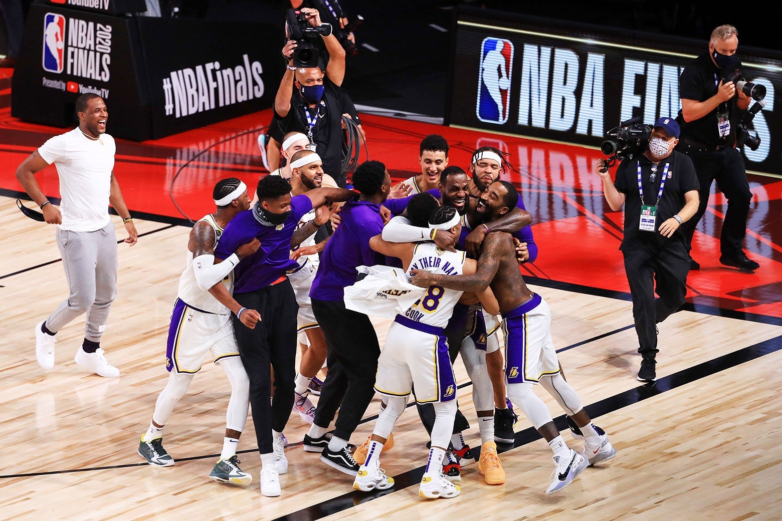 The Lakers hug one another on a gym floor.