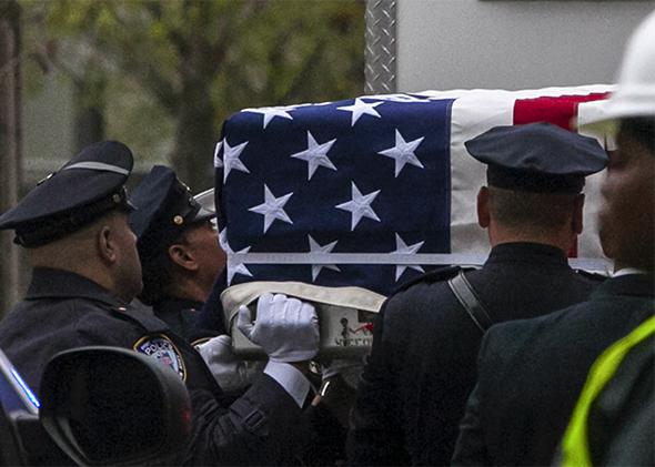Emergency personnel carry a casket draped with a U.S. flag during the ceremonial transfer of unidentified Sept. 11 remains from the medical examiner's office to a repository at ground zero on May 10, 2014.