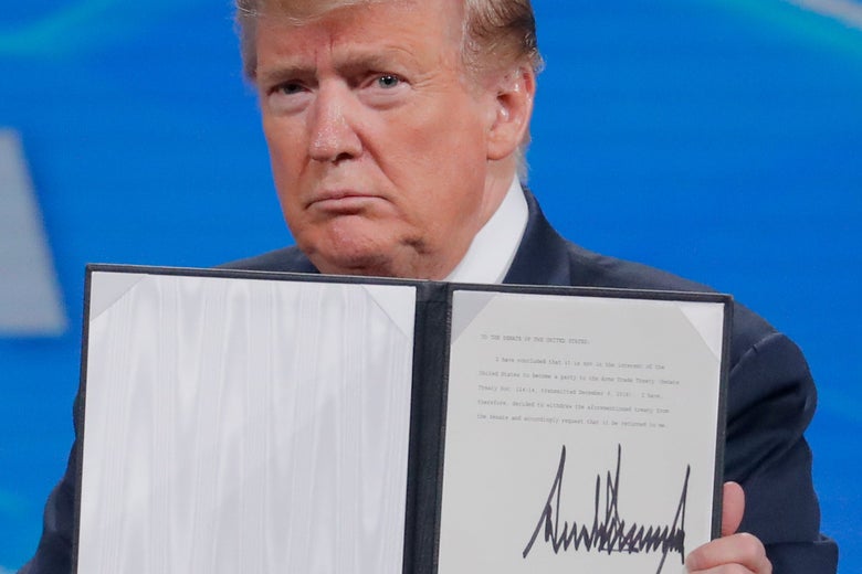 President Donald Trump holds up an executive order with his signature on it