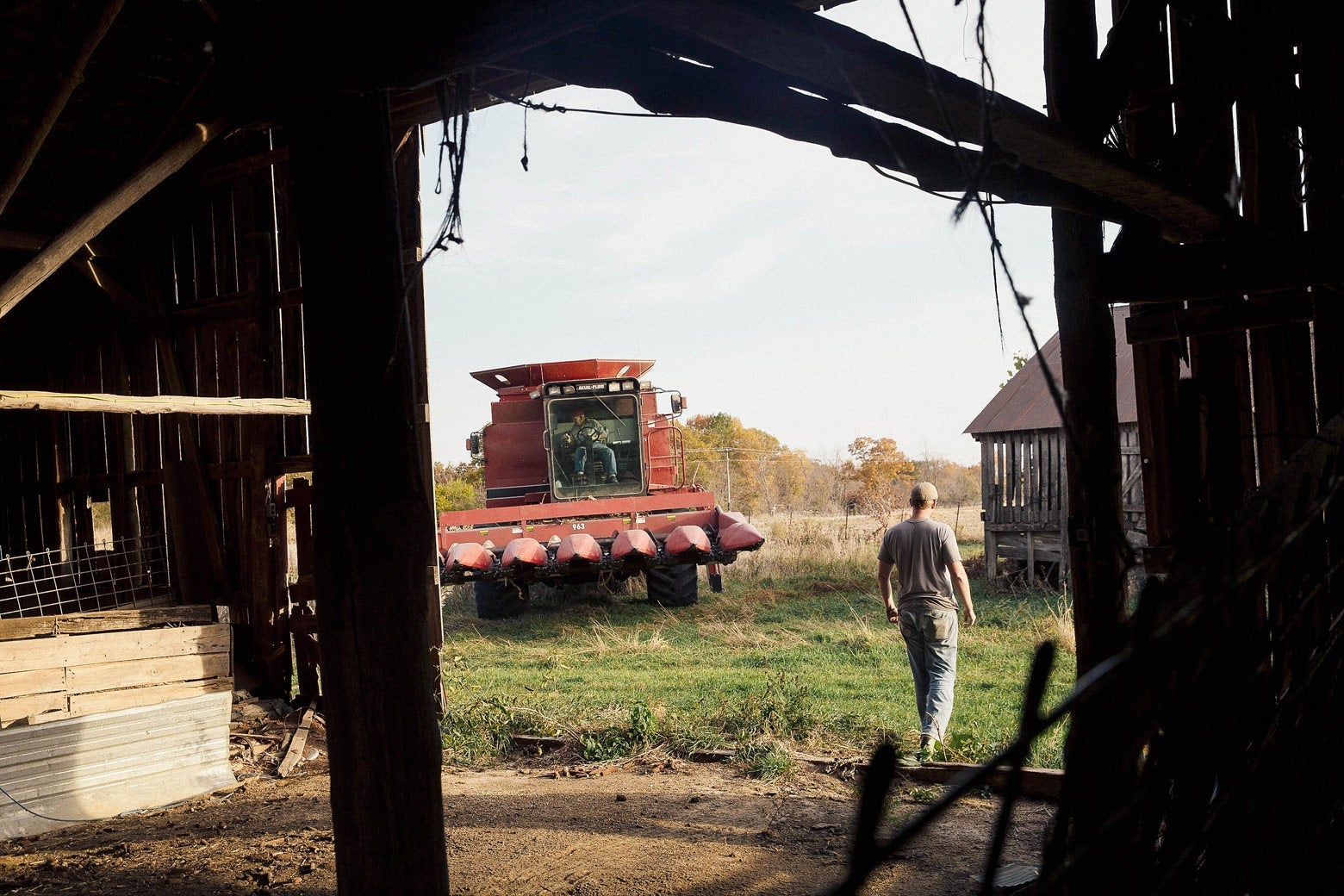 A tractor and a worker viewed from inside a barn in Wisconsin.