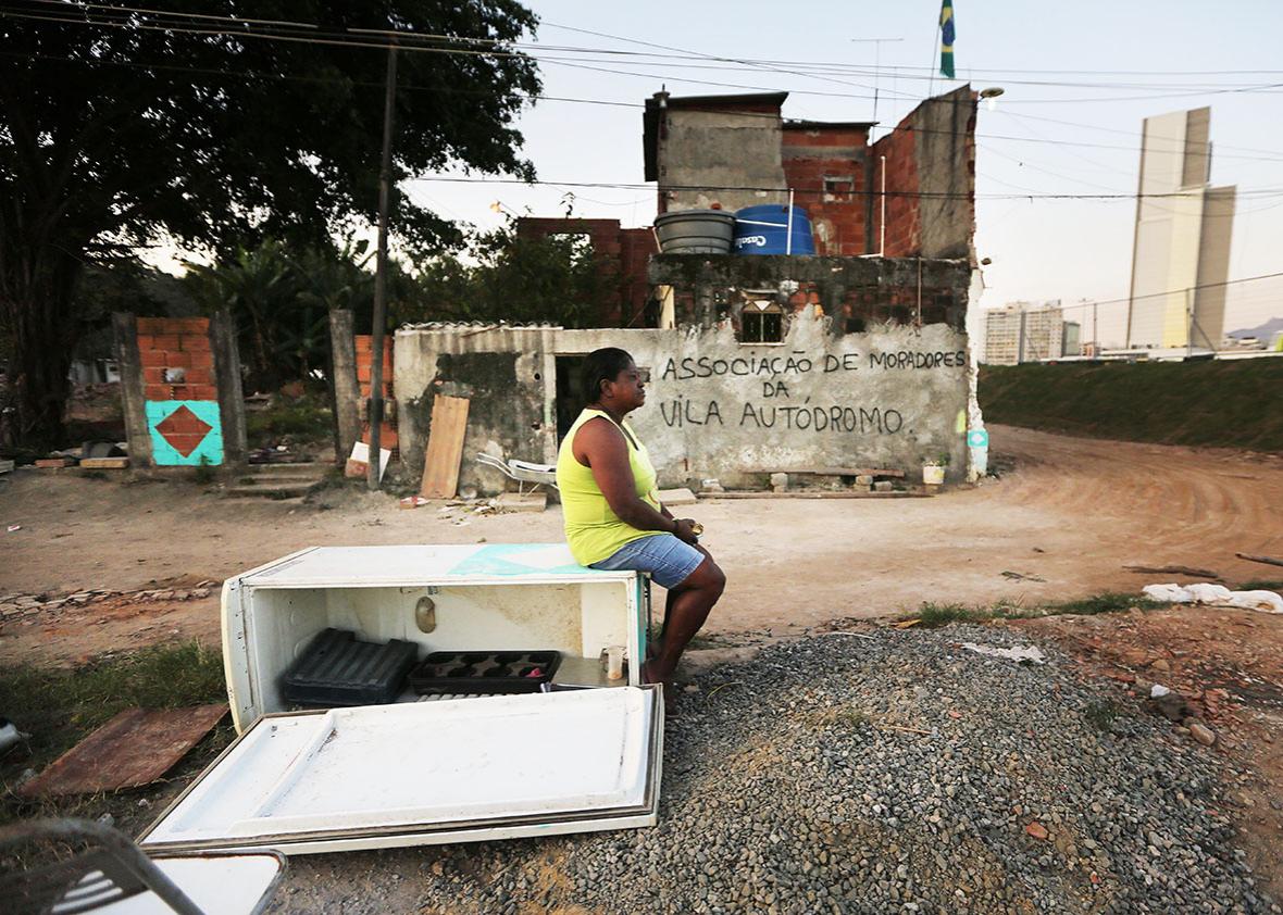 21-year resident Sandra Regina sits in front of her old home while in the process of moving out in the former Vila Autodromo 'favela' community, next to the Olympic Park, in the Barra da Tijuca neighborhood on August 1, 2016 in Rio de Janeiro, Brazil.