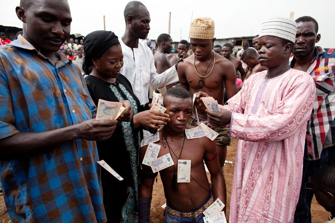 'Shago' Sumula Alabo is "sprayed" with money after a match in Lagos, Nigeria. At the end of the three rounds, a victor is declared but many times both the victor and his opponent will be “sprayed” with money (usually small denominations) from members of the audience in appreciation for their efforts and abilities.