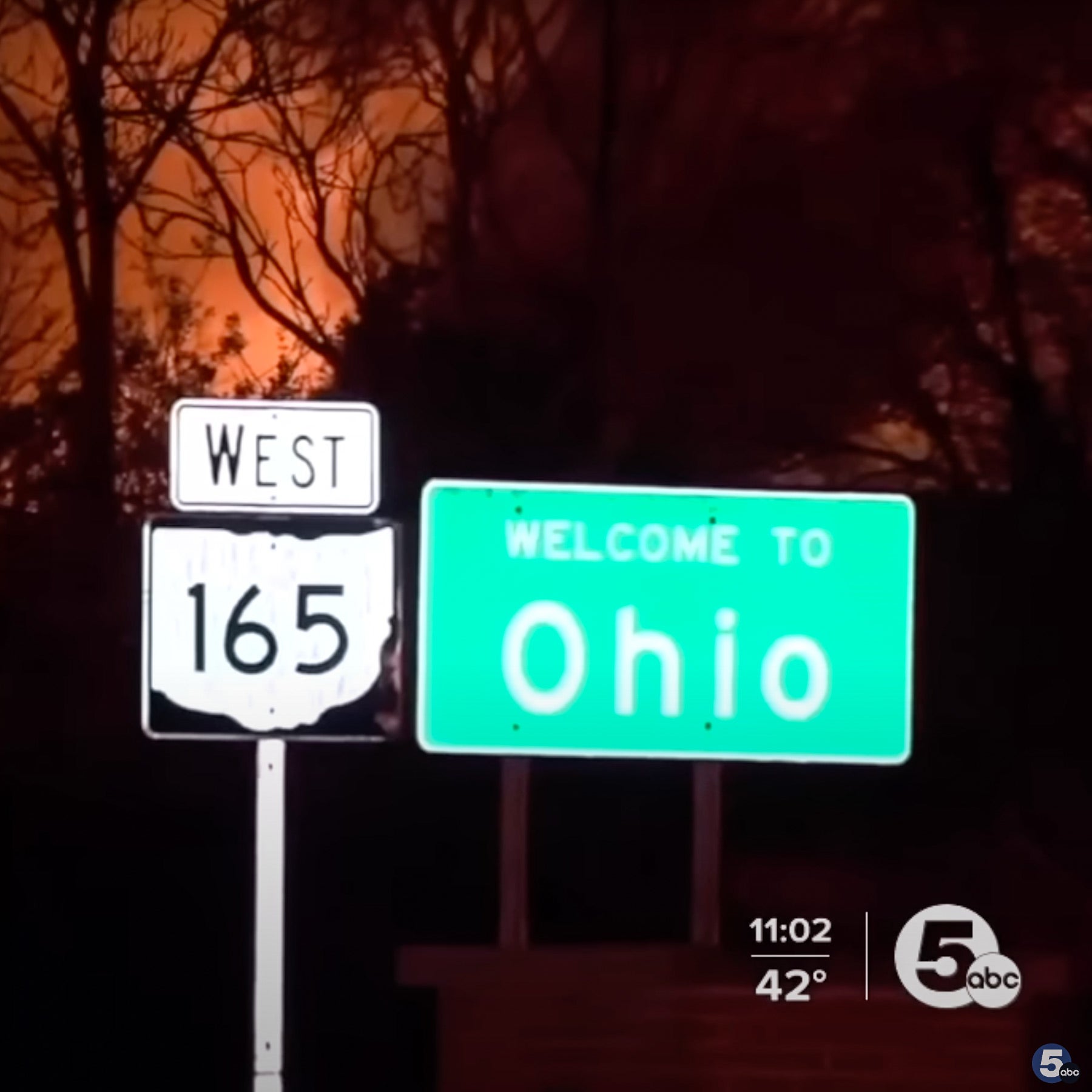 The Welcome to Ohio sign with flames behind it.