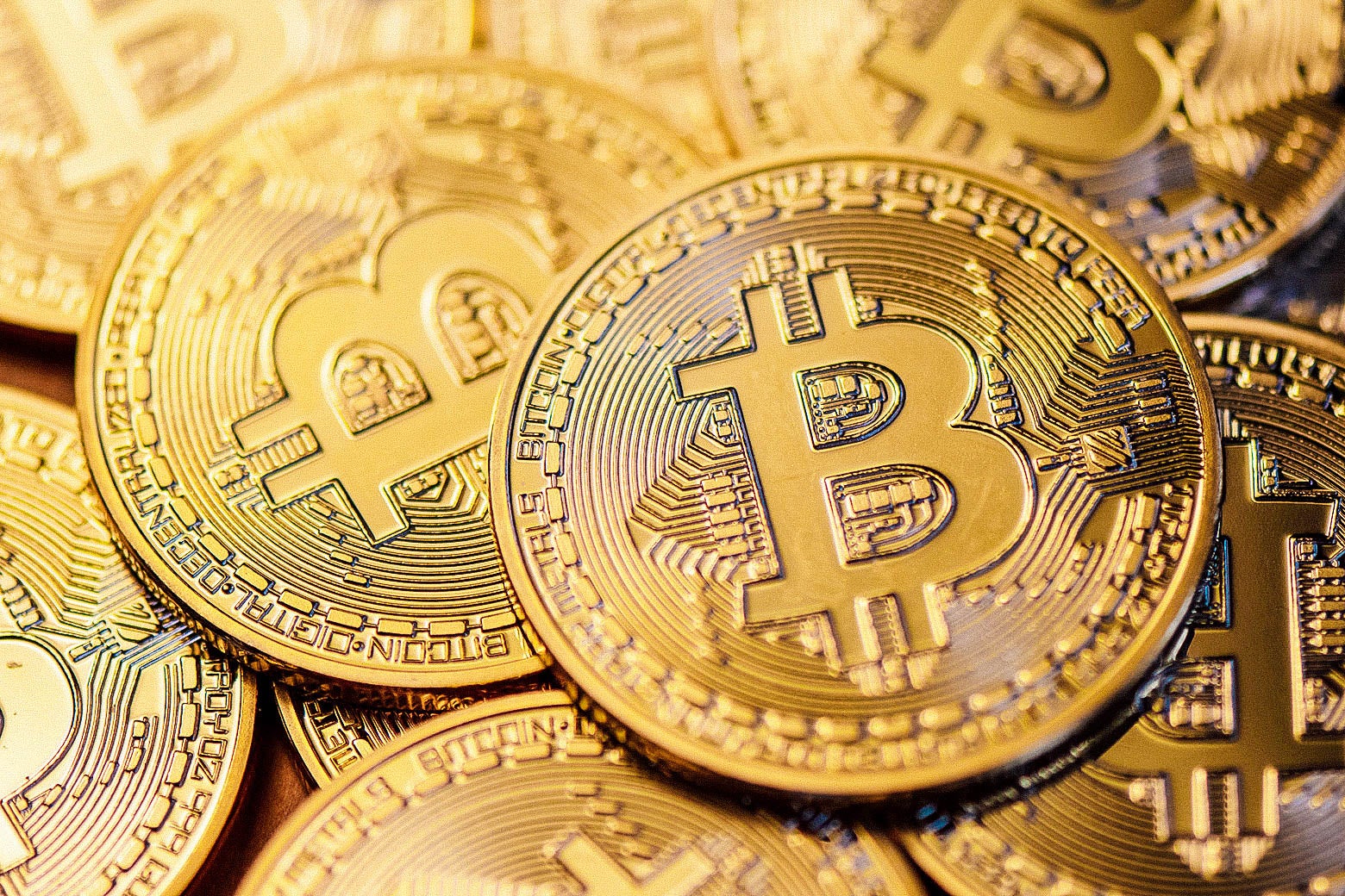 A pile of gold coins emblazoned with the letter B for bitcoin.