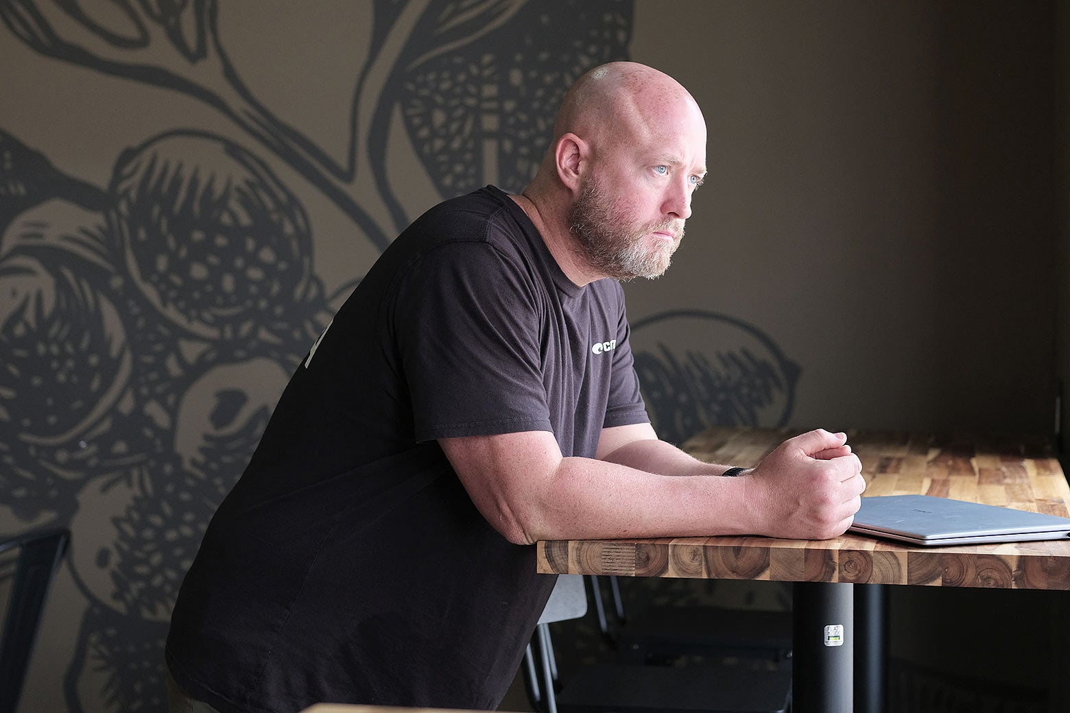 A bald man looking stressed out and contemplative.