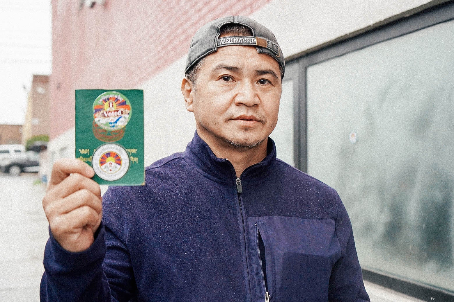 A man holds up a card showing he voted.