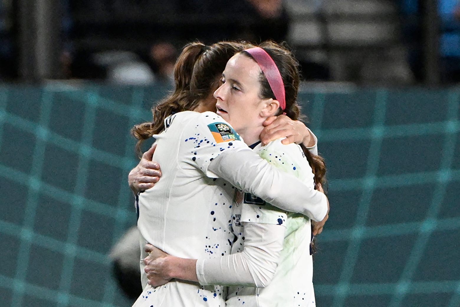 Rose Lavelle hugs a USWNT teammate, looking exhausted.