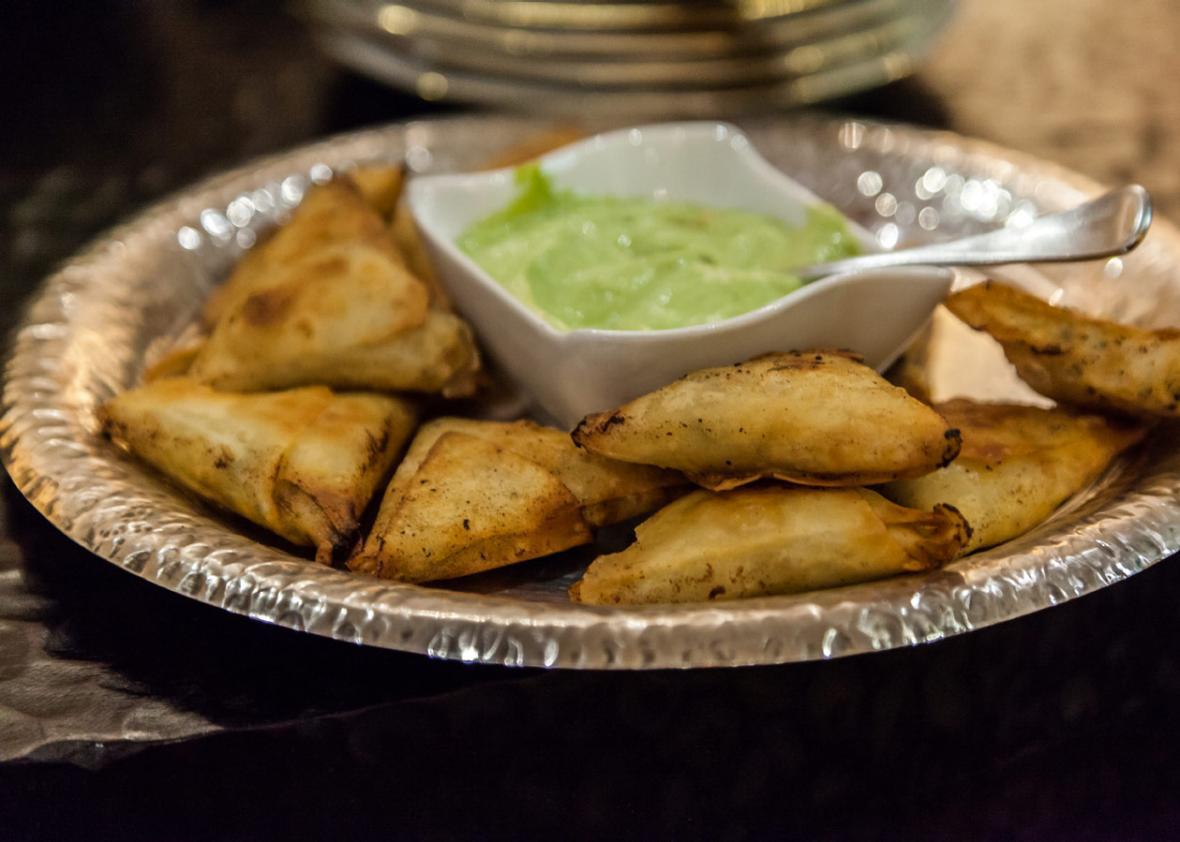 Hojaldries de karne (filo triangles with a meat filling) served with an avocado dip.