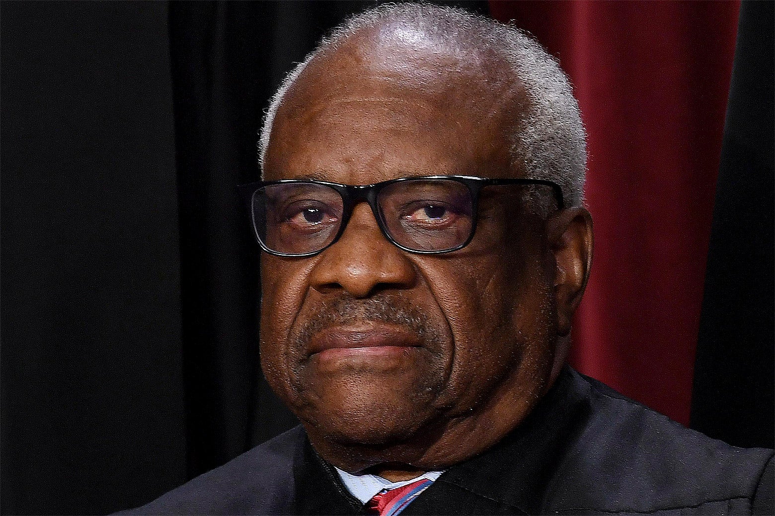 Justice Clarence Thomas in a robe, looking dour.