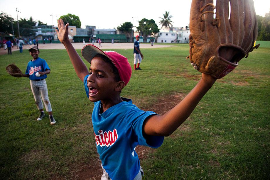 SANTO DOMINGO, DOMINCAN REPUBLIC. A young boy argues ball and strikes with a volunteer umpire during a practice game.