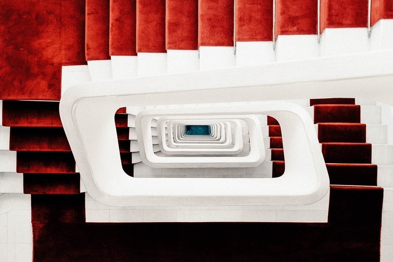 Overhead view of a red carpeted staircase descending many floors
