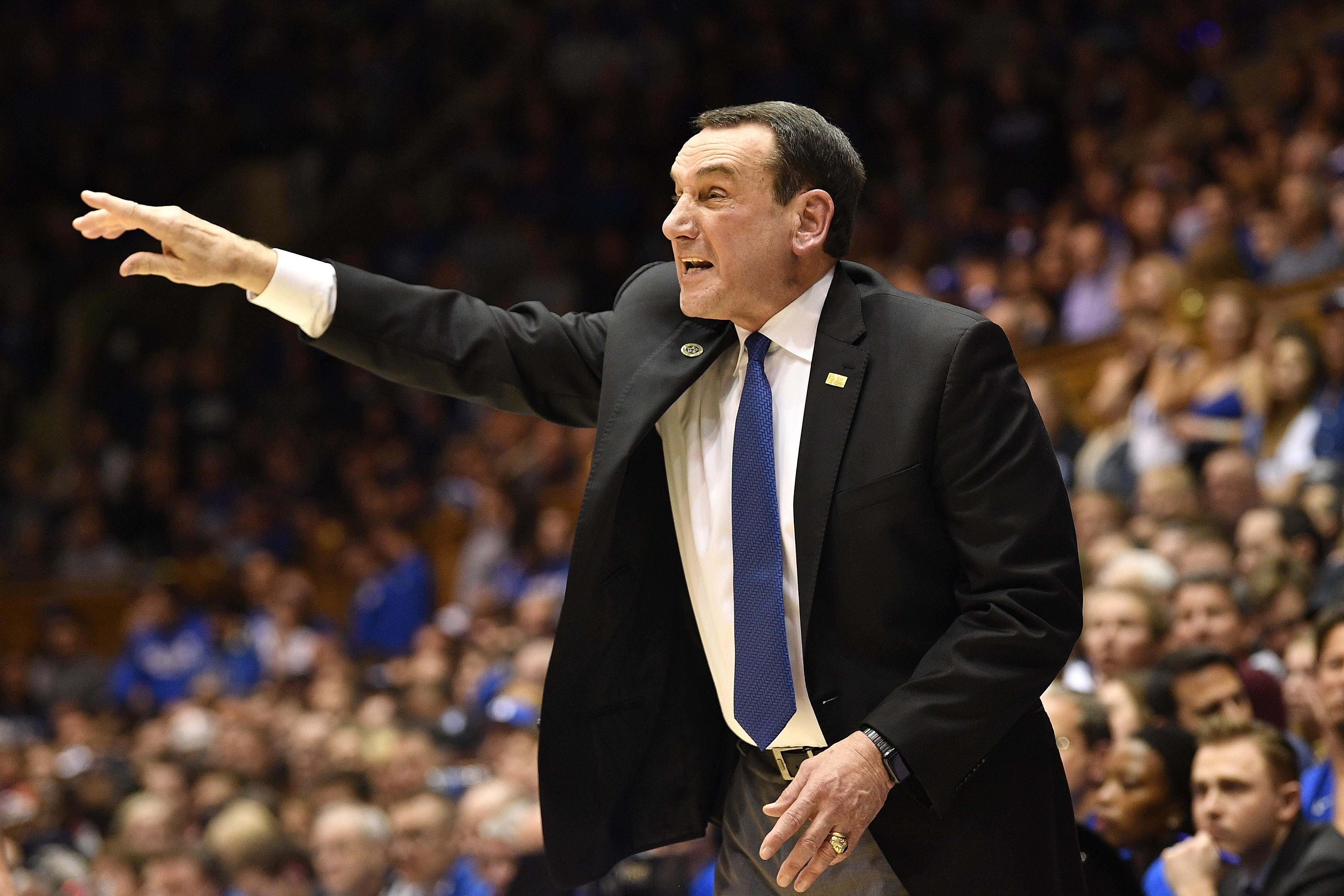 Coach K gesticulating and yelling in a suit on the sideline, as he does