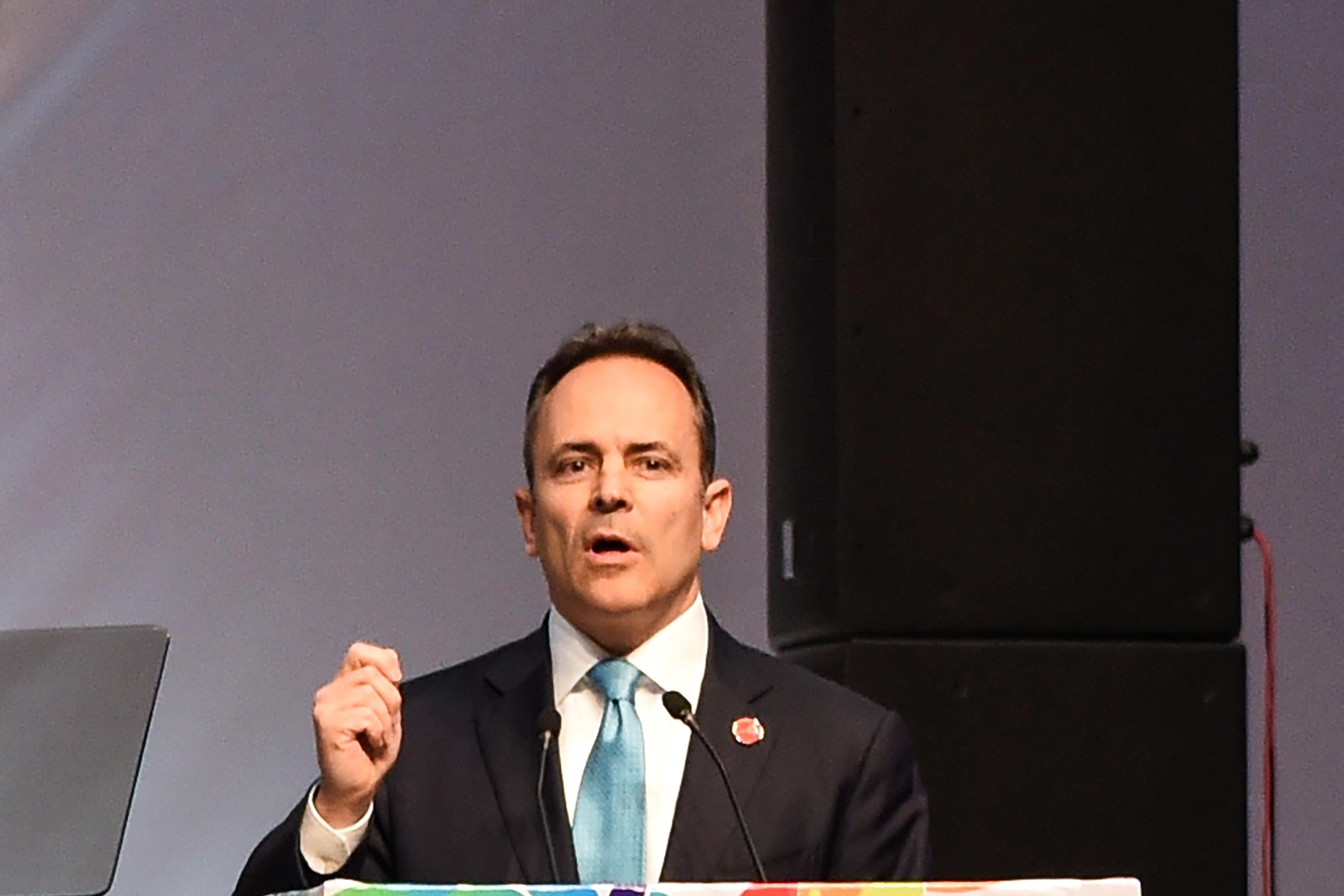 Bevin speaks at a colorful podium.