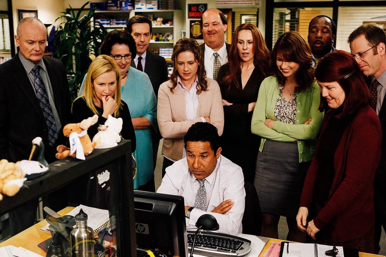 Everyone on The Office huddles around Oscar’s computer.