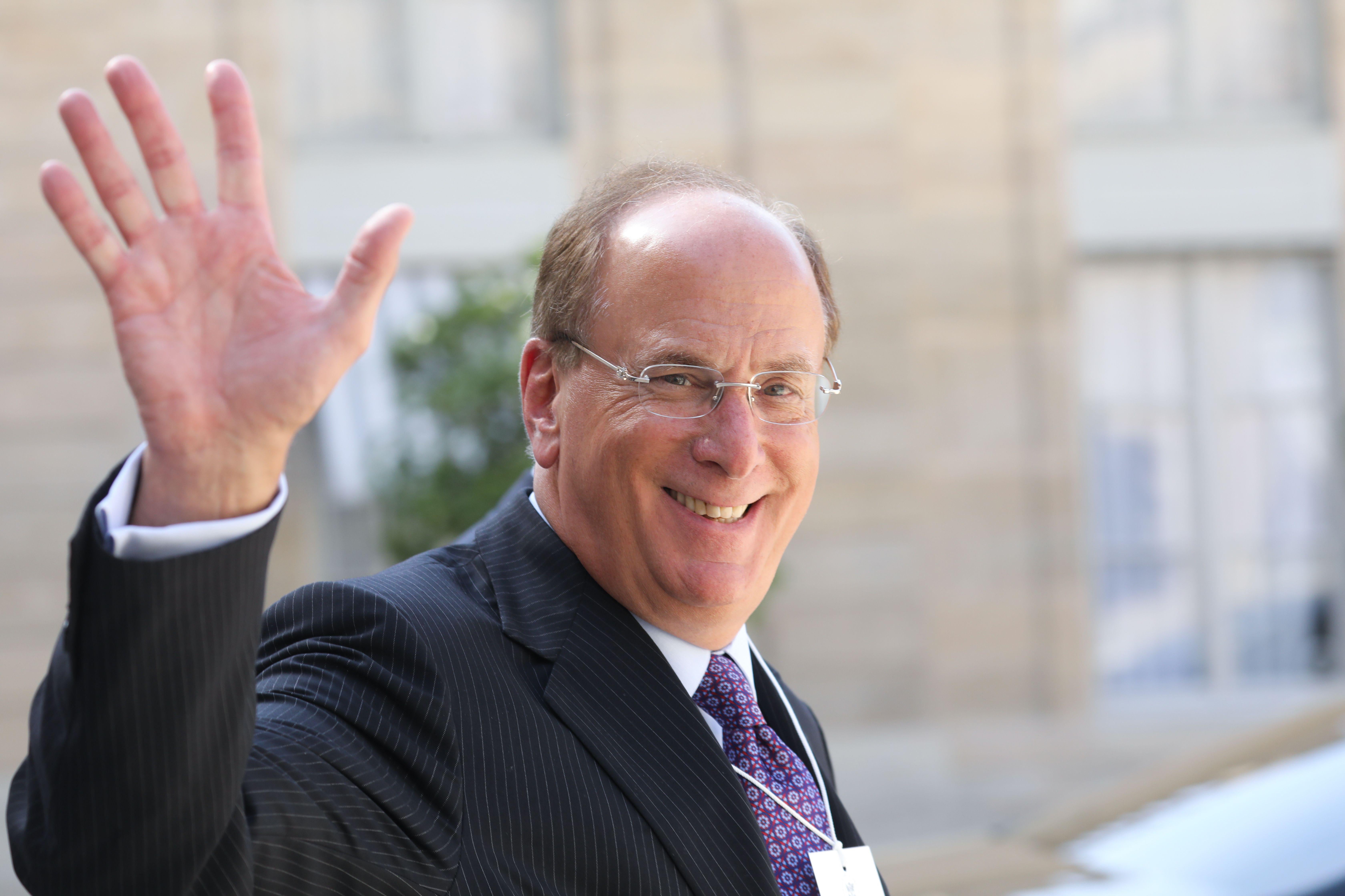 Chairman and CEO of BlackRock Larry Fink  waves as he leaves Elysee Palace.