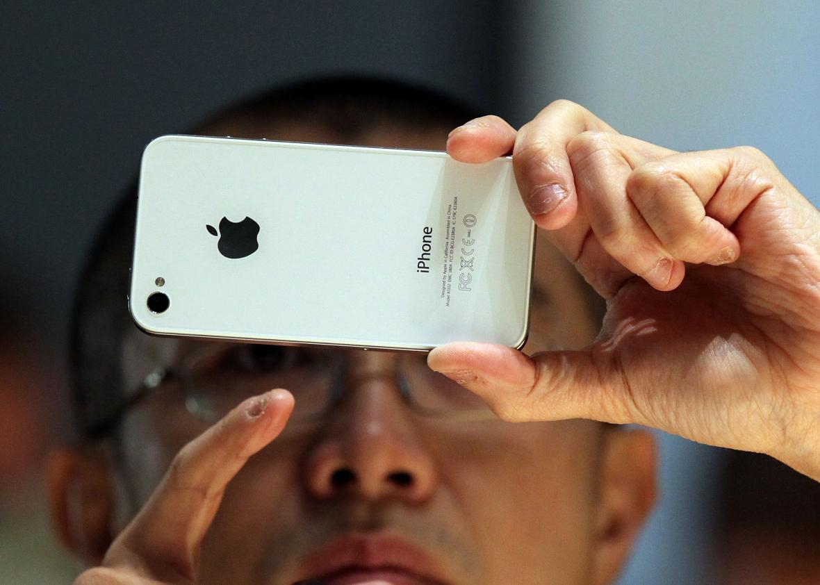 A member of the media inspects the then-new iPhone 4 in 2010. Apple can't access the contents of newer iPhones, but the government thinks it should turn over data on older iPhones when requested.