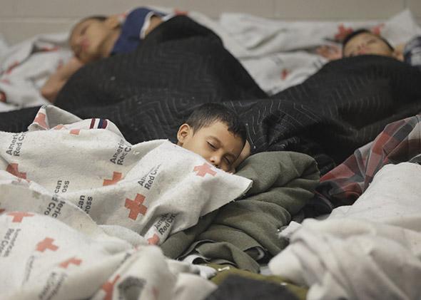 Detained children sleep in a holding cell at a U.S. Customs and Border Protection processing facility in Browsnville, Texas, on June 18, 2014.