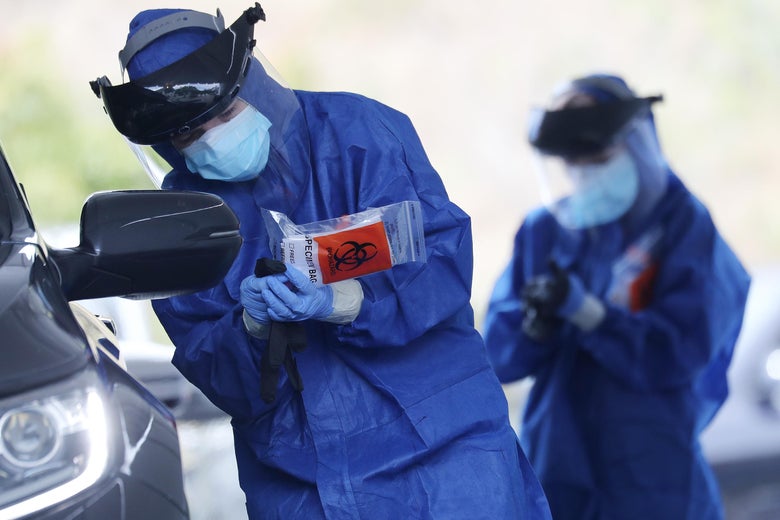 A volunteer holds a specimen bag while conducting drive-through coronavirus testing at Malibu City Hall on April 8, 2020 in Malibu, California.