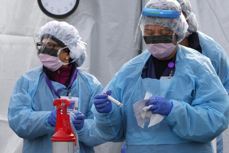Nurses process a sample for COVID-19 after a patient was screened at an appointment-only, drive-up clinic in Seattle, Washington, an epicenter of the outbreak.