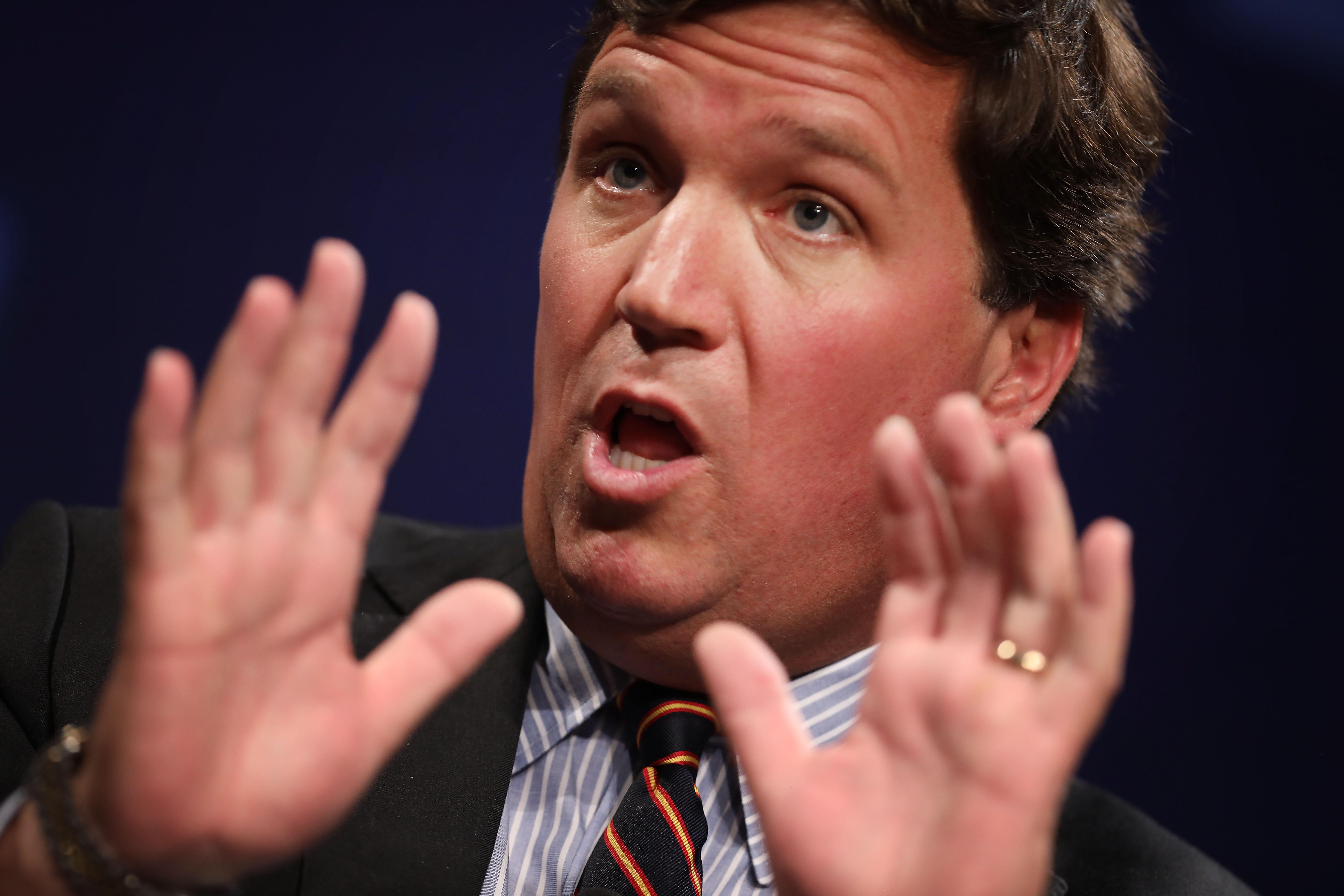 Tucker holds his hands up as if he's done nothing wrong.