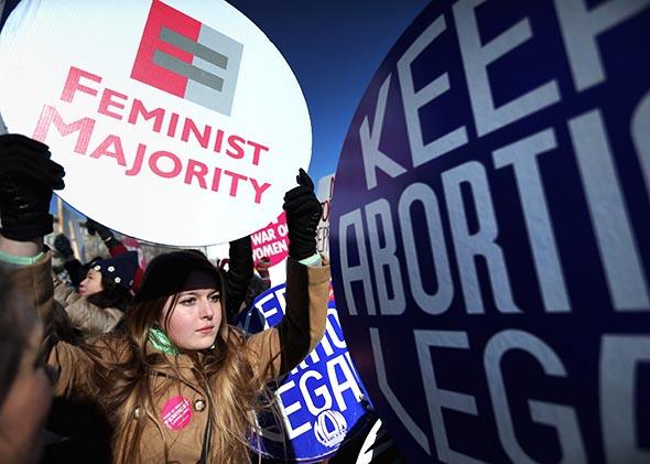 Pro-choice activist and Feminist Majority Foundation intern Jade Reindl holds a sign as participants in the annual March for Life arrive in front of the U.S. Supreme Court on Jan. 22, 2014, in Washington, D.C.