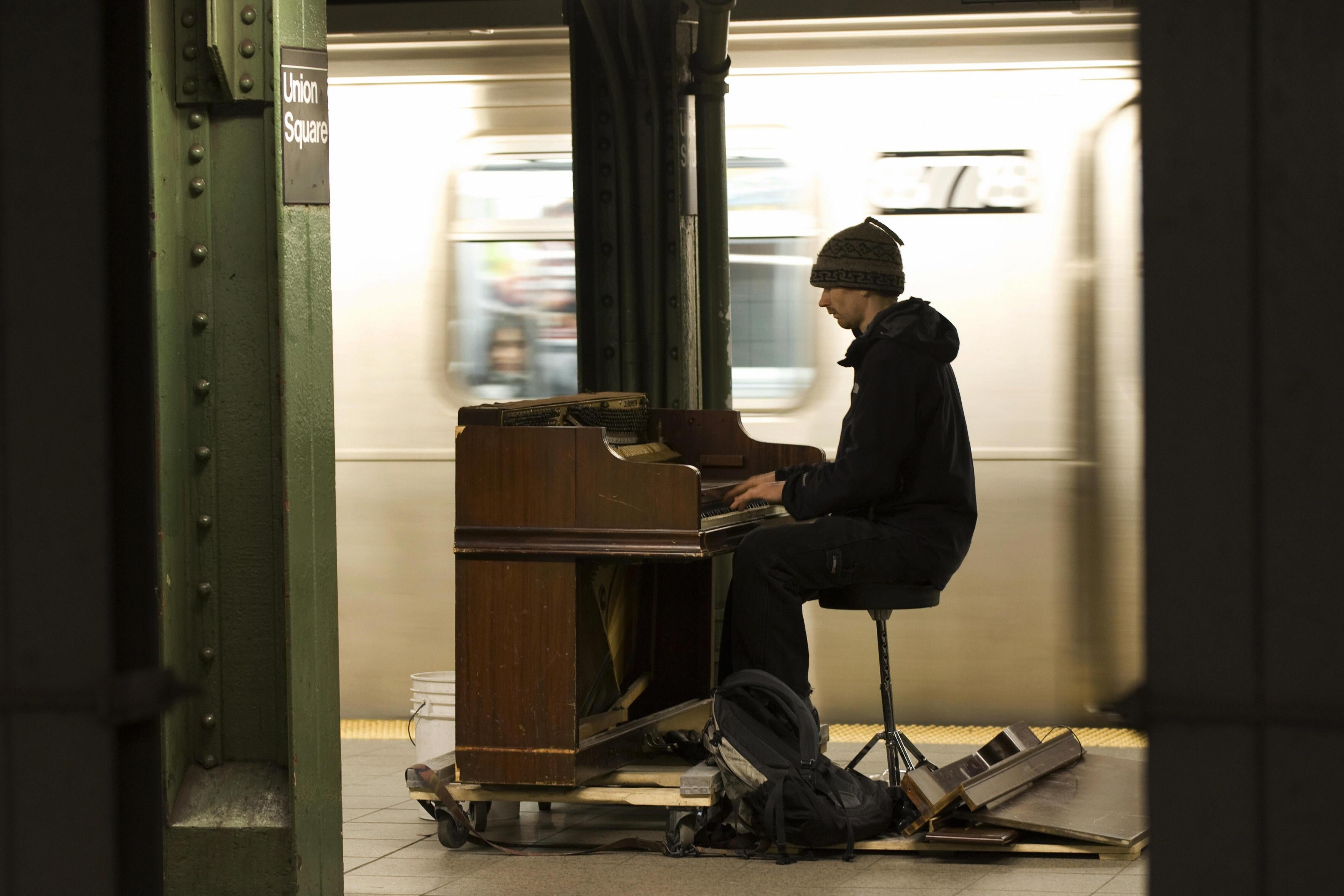 Pianist Colin Huggins plays for subway riders at the Union Square station.