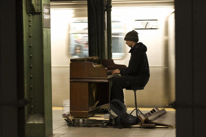 Pianist Colin Huggins plays for subway riders at the Union Square station.