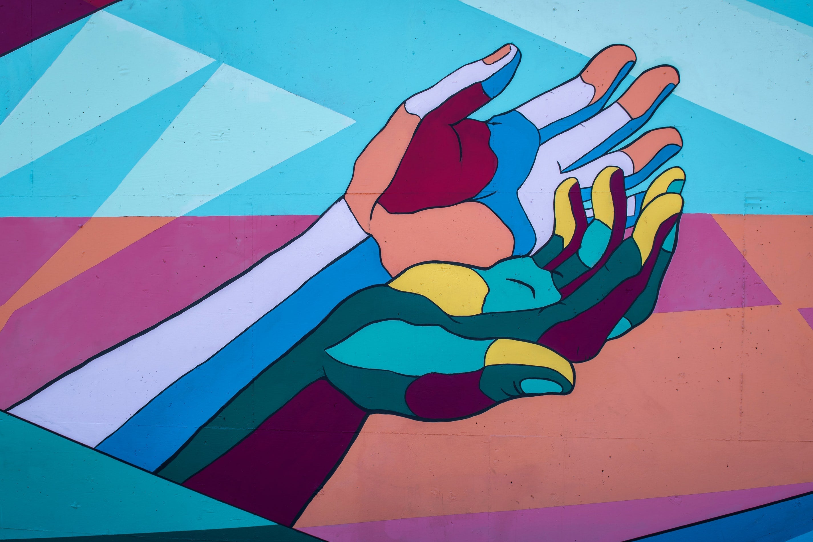A mural of two brightly and surreally colored hands.