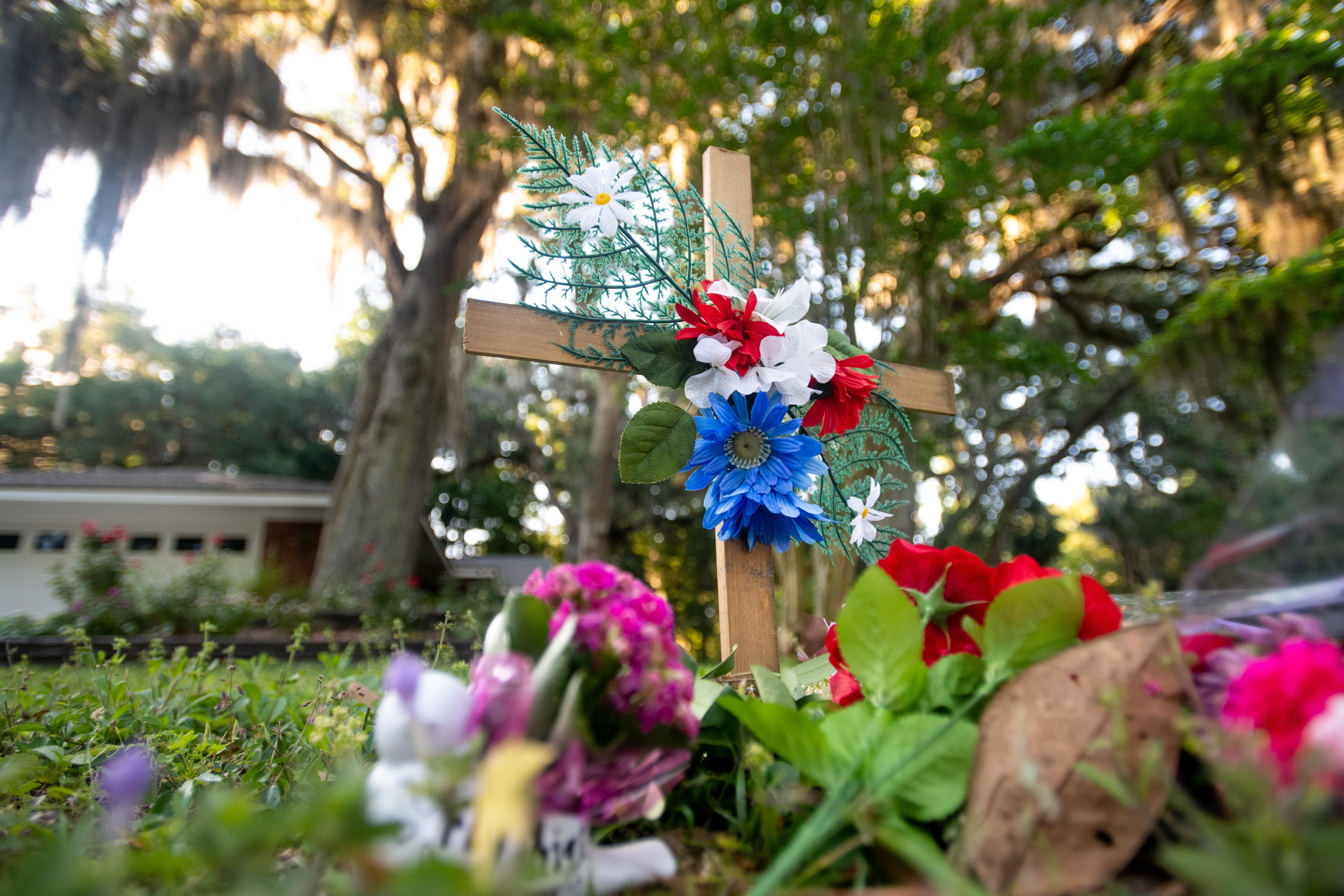 A commemorative cross with flowers in the Georgia neighborhood where Ahmaud Arbery was shot and killed.