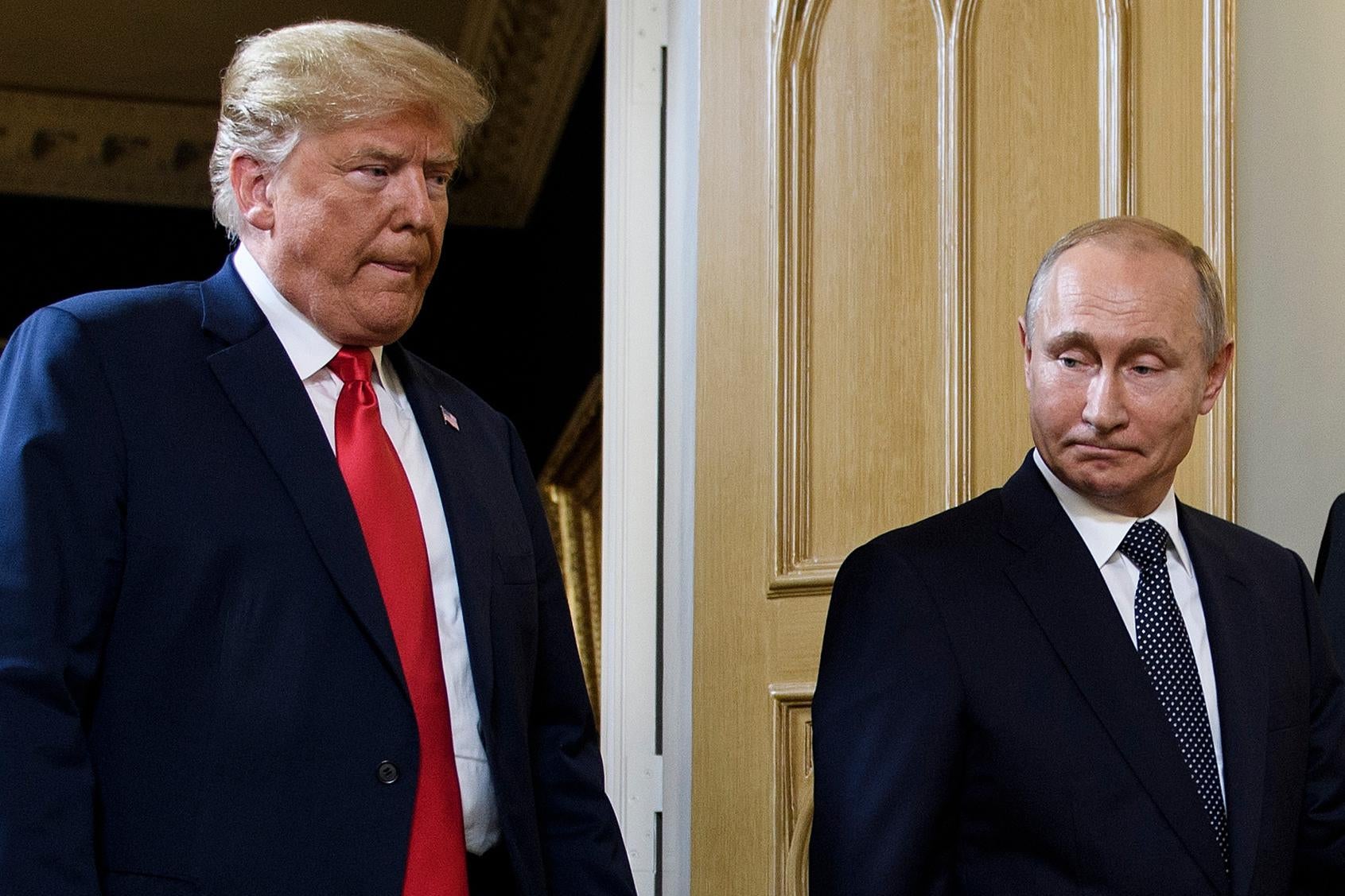 Donald Trump and Vladimir Putin stand beside each other.