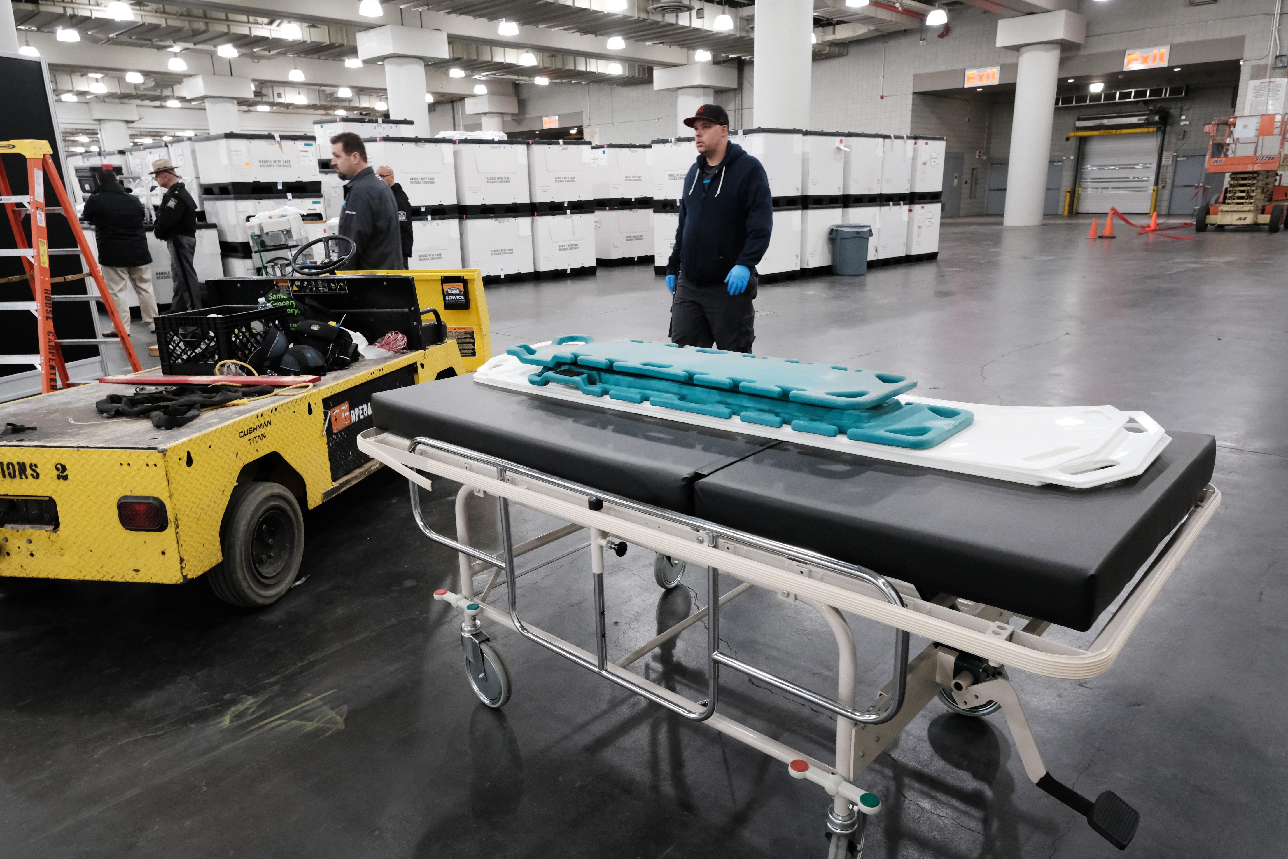 Workers load medical beds and other supplies into the Javits Center.