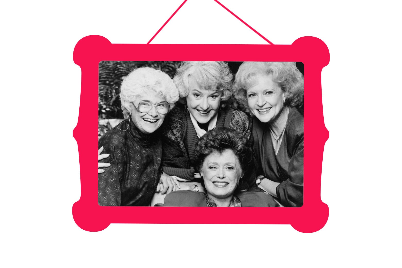 The Golden Girls cast smiling in a photo hung in a picture frame.