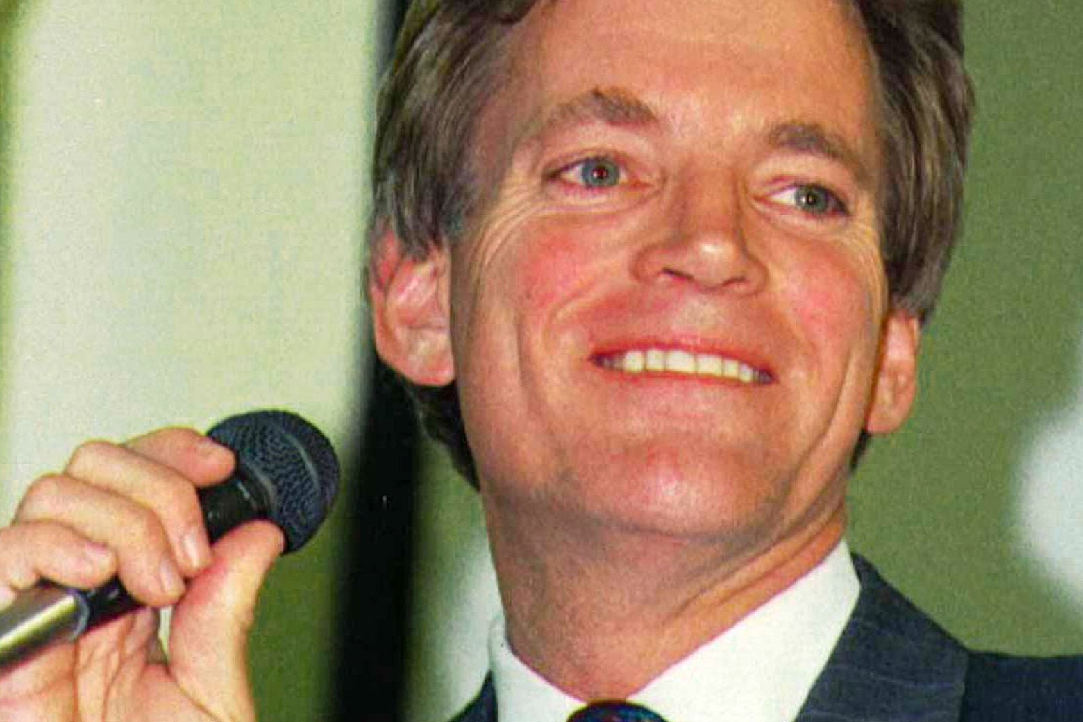 Close-up of David Duke smiling and holding a microphone.
