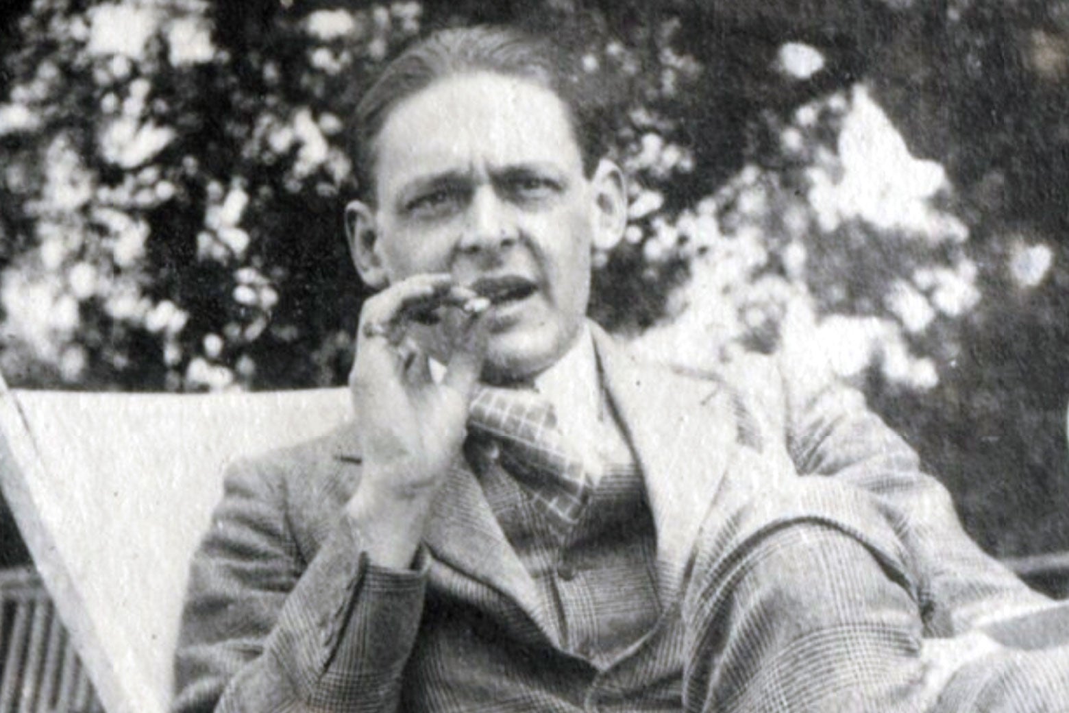 A black-and-white photo of T.S. Eliot smoking a cigar.
