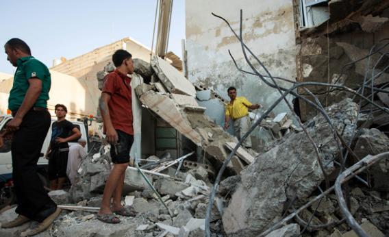 Syrians inspect debris after a bomb hit a building during clashes between rebel fighters and Syrian government.