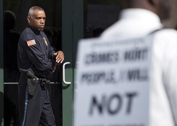 police officer watches protestors at a rally in North Charleston, South Carolina.