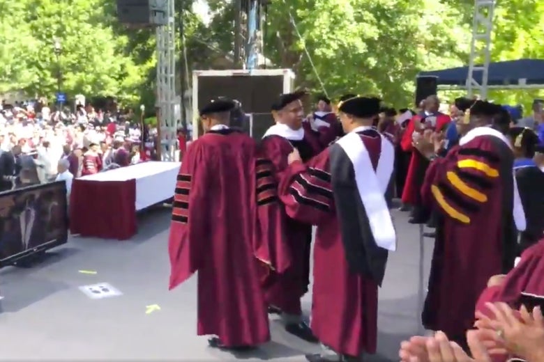 Robert Smith and others in academic robes onstage at Morehouse commencement.