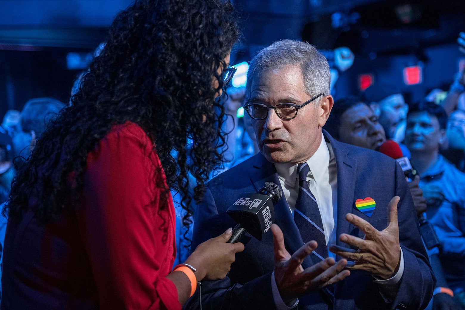 Krasner talks to a reporter amid a crowd of people.