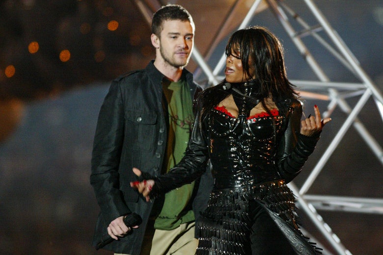 Justin stands beside Janet holding a microphone.