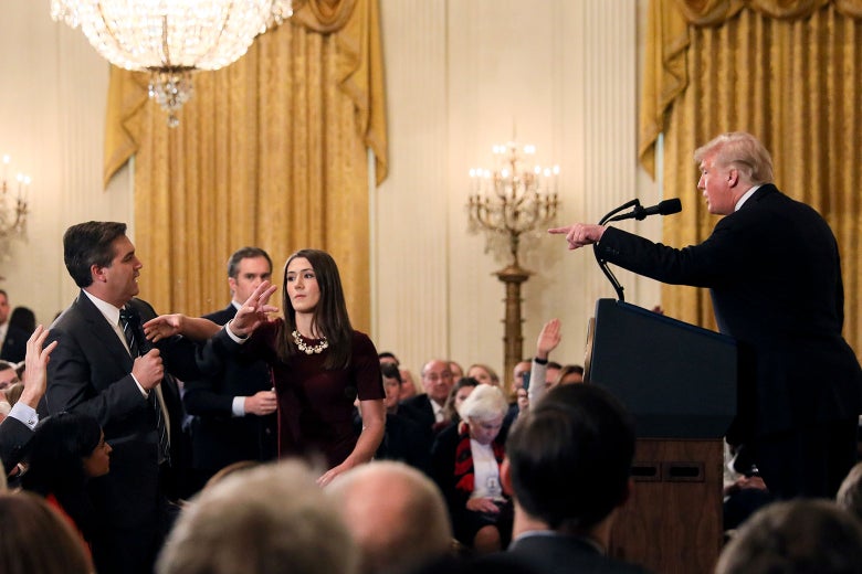 A White House staff member reaches for the microphone held by CNN's Jim Acosta as he questions U.S. President Donald Trump on Wednesday.