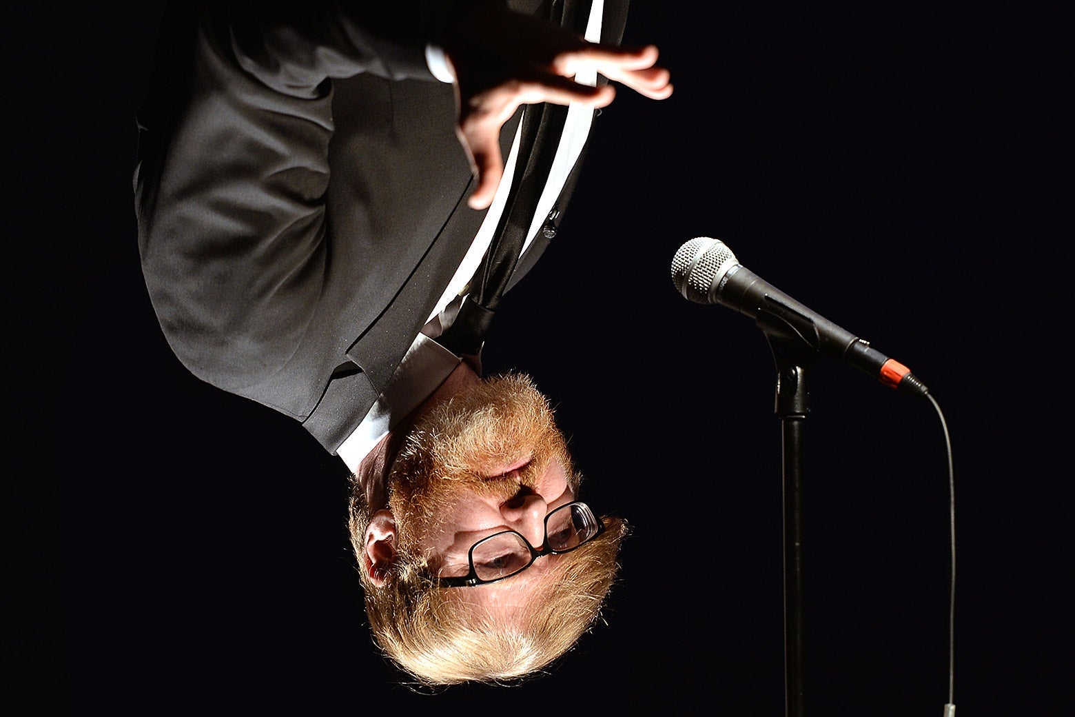 Klosterman photoshopped upside-down speaking at a mic