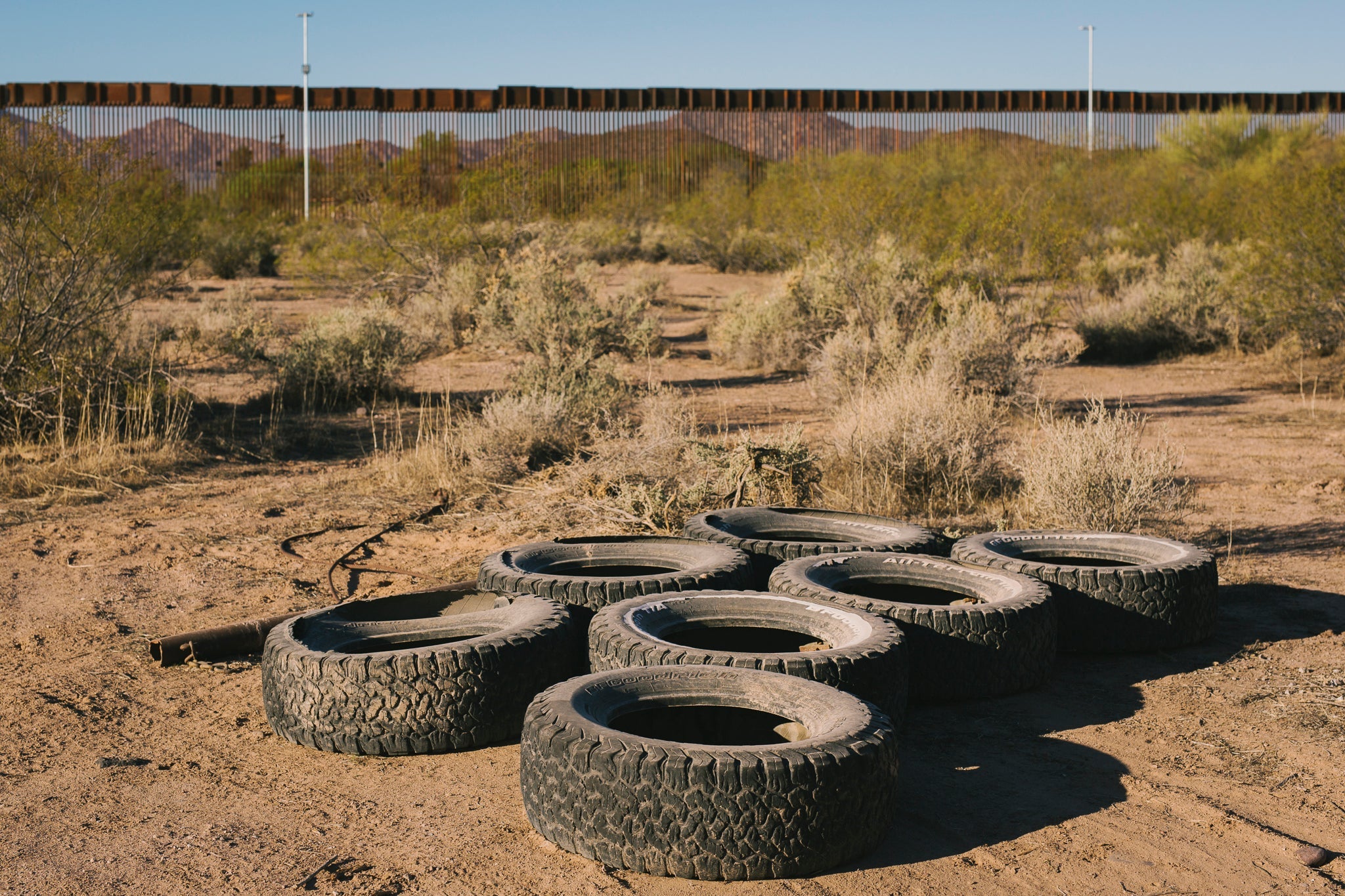 Several dusty tires sit in the desert.