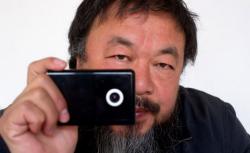 Artist Ai Weiwei holds a webcam.
