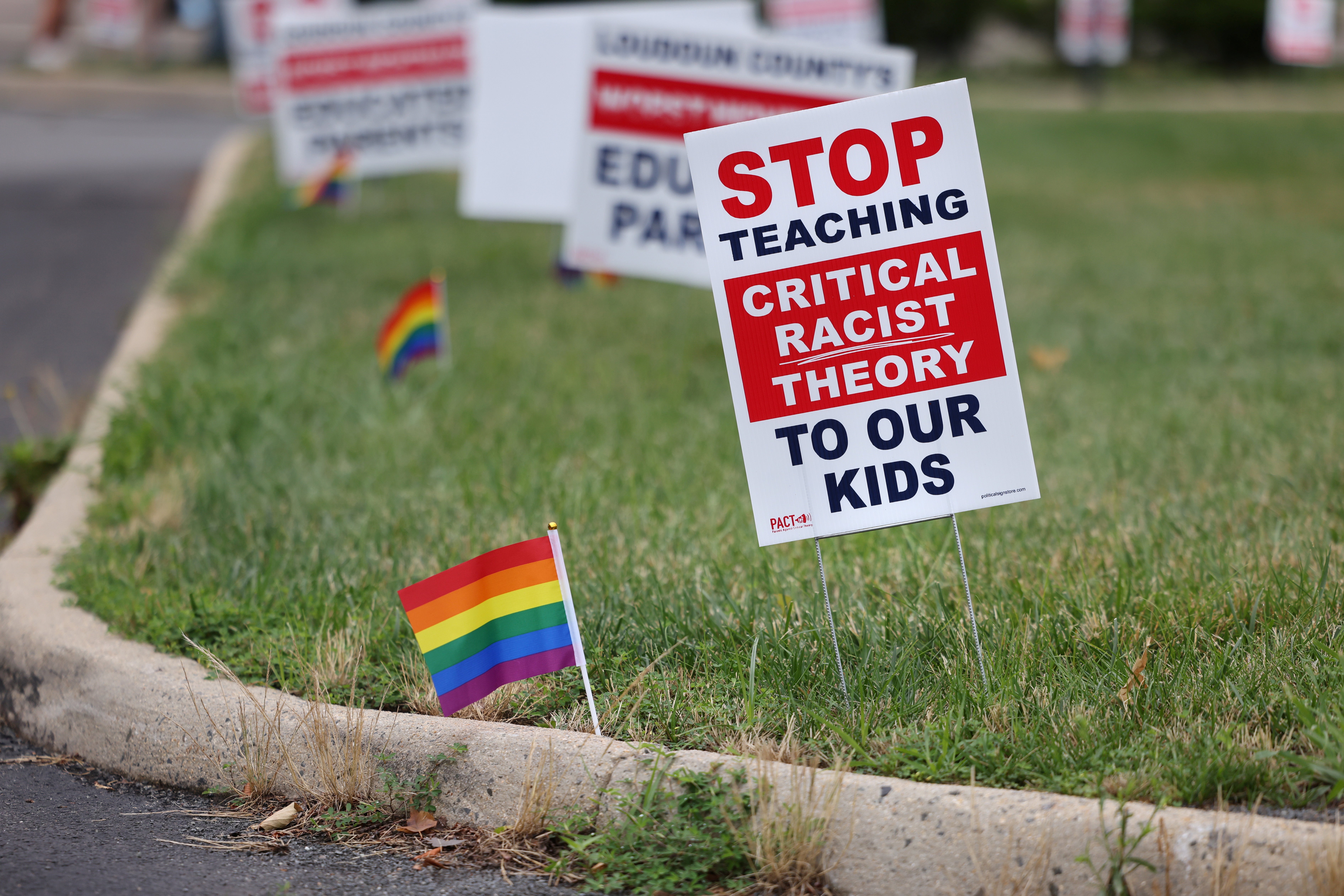 A sign that says "Stop Teaching Critical Racist Theory to Our Kids" standing on grass