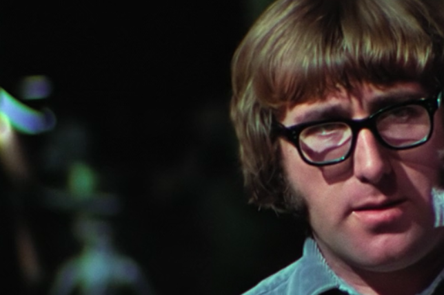 A man with a mop top haircut wearing black glasses