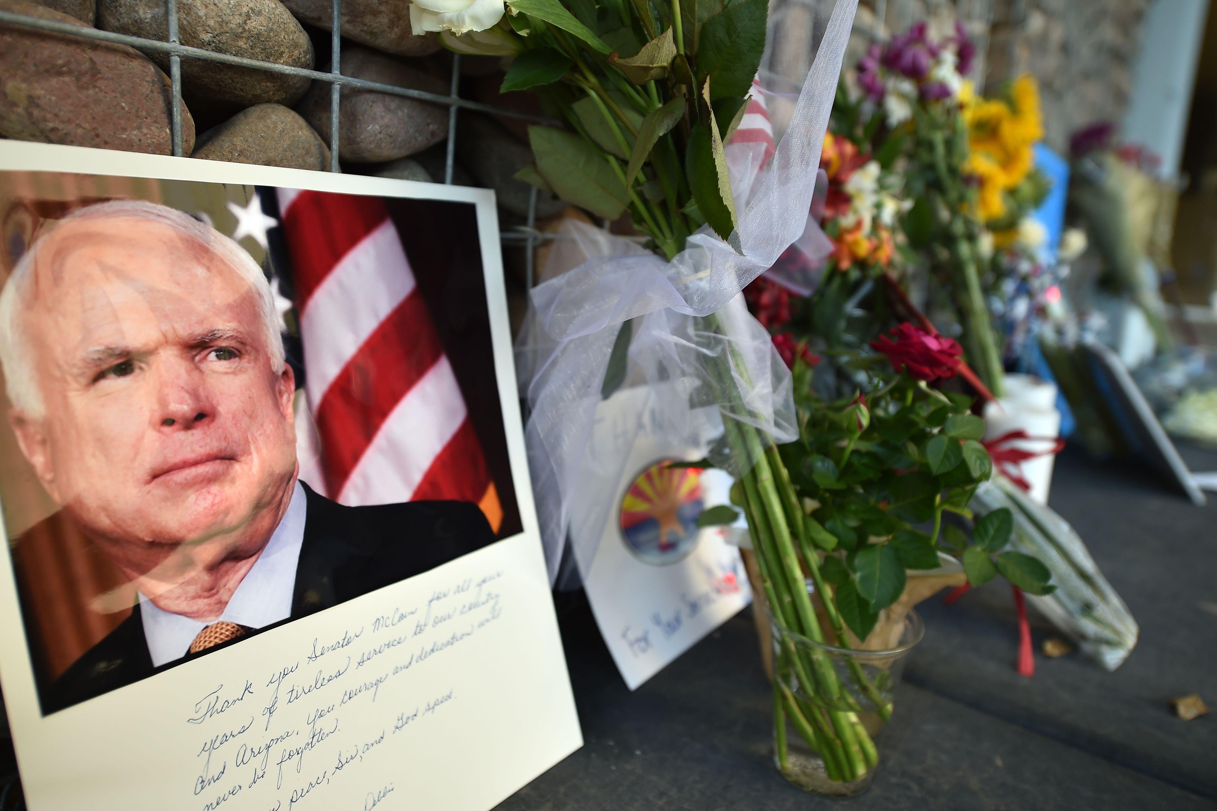 A memorial of flowers, notes, and photographs outside John McCain's Phoenix office.