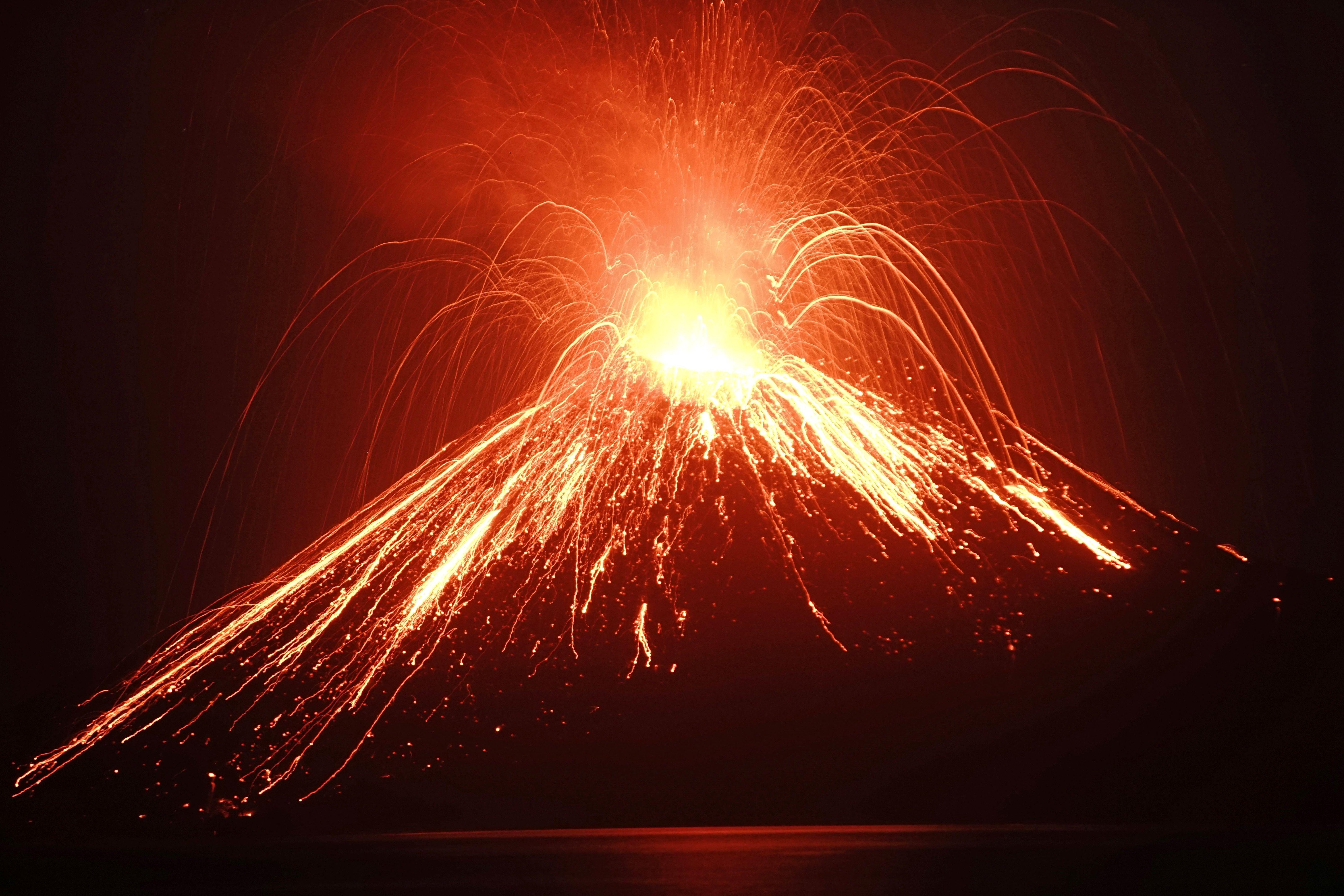 Lava streams down from Anak Krakatau (Child of Krakatoa) volcano during an eruption as seen from Rakata island in South Lampung on July 19, 2018. - An Indonesian volcano known as the 'child' of the legendary Krakatoa erupted on July 19, spewing a plume of ash high into the sky as molten lava streamed down from its summit. Anak Krakatau -- a small volcanic island that emerged from the ocean a half century after Krakatoa's deadly 1883 eruption -- has rumbled back to life in recent weeks, spitting flaming rocks and ash from its crater. (Photo by FERDI AWED / AFP) (Photo credit should read FERDI AWED/AFP/Getty Images)