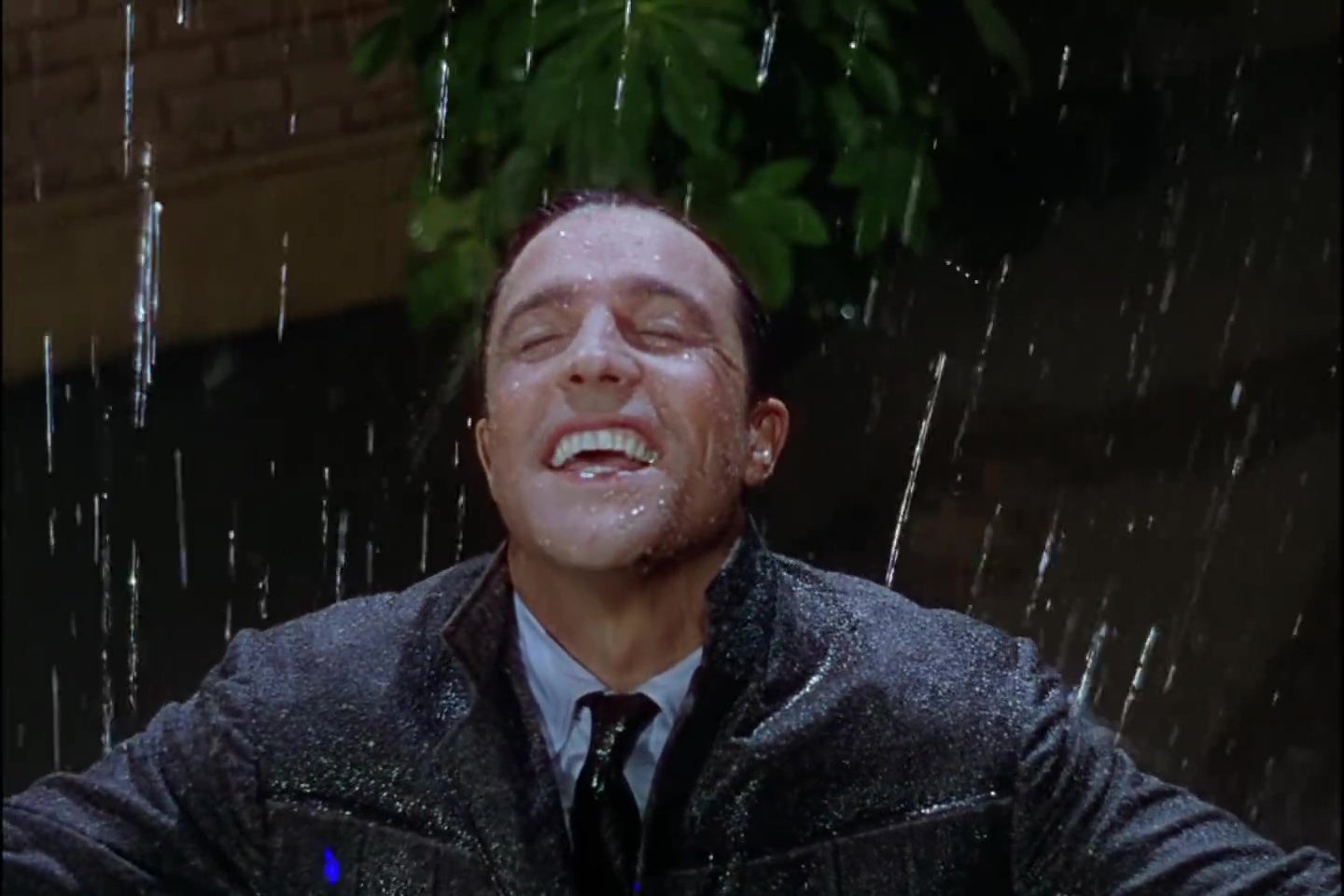 Gene Kelly smiling in a downpour in Singin' in the Rain.