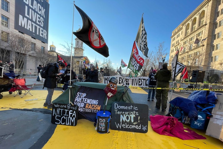 A few protesters with signs that say "We are proud antifa scum," "Black Lives Matter," and "Domestic terrorists not welcomed"